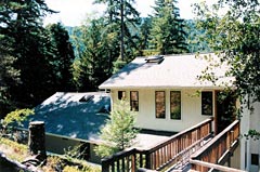 A house with a deck and trees in the background