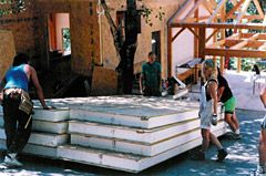 A couple of people standing next to some stacks of foam.